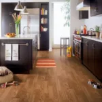 Modern kitchen with wooden floors and dark cabinets.