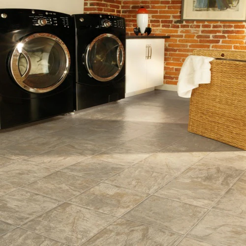 Modern laundry room with black appliances and tile flooring.