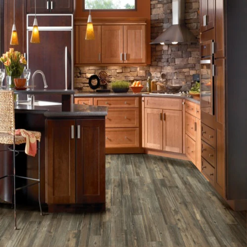 Modern kitchen with wooden cabinets and stone backsplash.