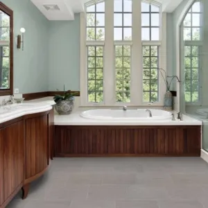 Bathroom with large windows, bathtub, and wooden cabinets.