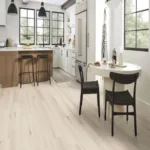 Modern kitchen with wooden flooring and white cabinets.