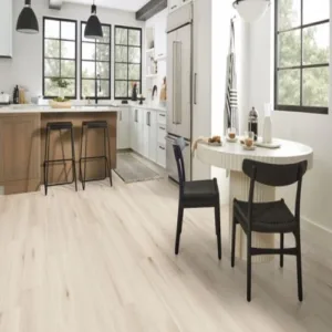 Modern kitchen with wooden flooring and white cabinets.