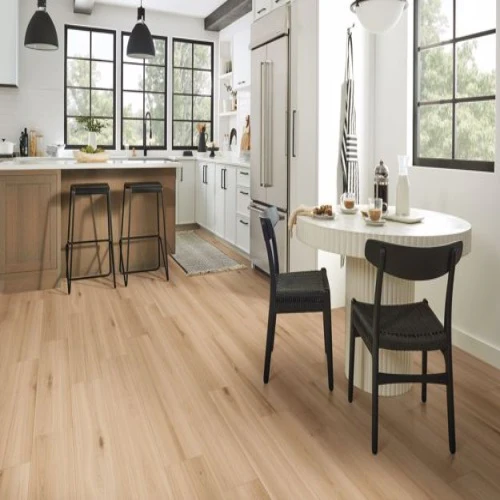 Modern kitchen with wood flooring and white cabinets.