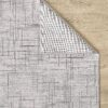 Gray patterned rug on wooden floor background.