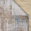 Textured rug on wooden floor, corner folded.