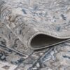 Close-up of rolled gray-blue patterned rug.