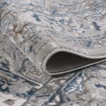 Close-up of rolled gray-blue patterned rug.