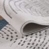 Close-up of abstract patterned rug corner.