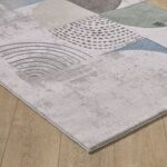 Abstract patterned rug on wooden floor.