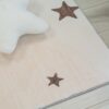 White star pillow on wooden floor beside rug