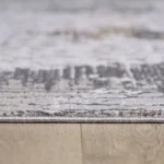 Close-up of a textured rug on wooden floor.