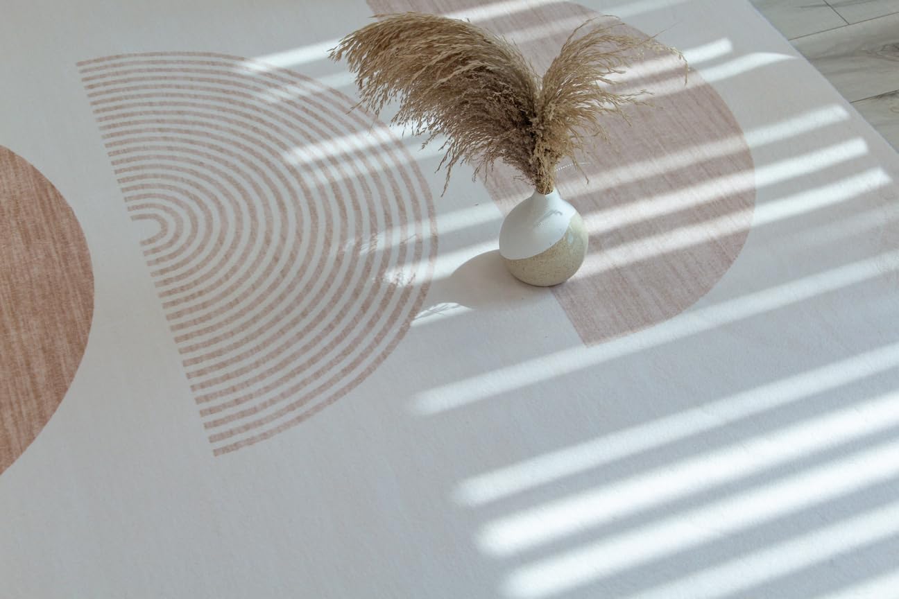 Modern ceramic vase with dry grass on abstract rug.