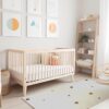 Modern nursery with crib and geometric wall art.