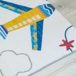 Colorful airplane design children's rug on wooden floor.