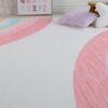 Colorful rainbow rug with pillows in children's room.