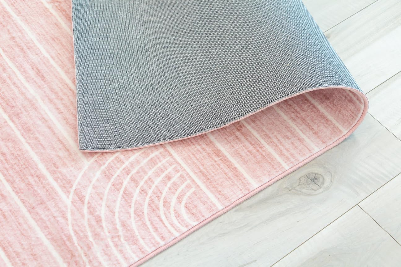 Folded pink and gray rug on wooden floor.
