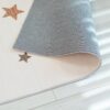 Folded star-patterned carpet on wooden floor.