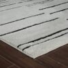White rug with black stripes on wood floor.