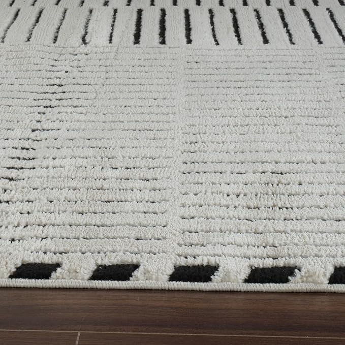 White and black patterned rug on wooden floor
