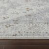 Textured beige patterned rug on wooden floor.
