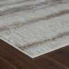 Textured rug on wooden floor, beige and brown pattern.