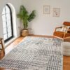 Modern living room with patterned rug and chair.