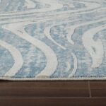 Blue and white wavy pattern rug on wood floor.