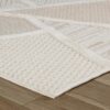 Textured beige area rug on wooden floor
