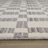 Gray and cream checkered area rug on wood floor