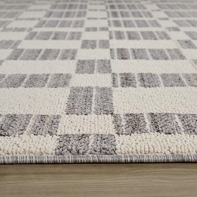 Gray and cream checkered area rug on wood floor