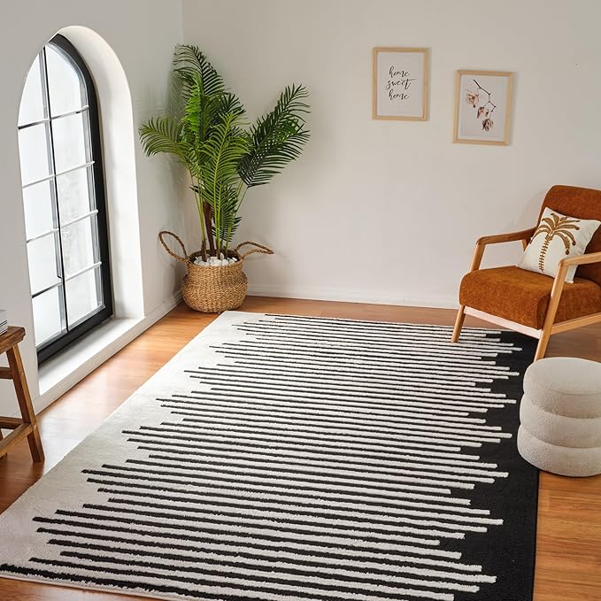Modern living room with striped rug and plants.