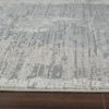 Textured gray area rug on wooden floor.