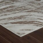 Textured beige and white rug on wooden floor.