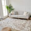 Modern living room with gray sofa, patterned rug.