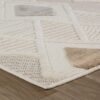 Beige and white geometric patterned rug on wood floor.