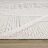 Close-up of textured off-white area rug corner.