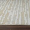 Beige and white patterned area rug on wooden floor.