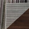 Striped rug corner folded on wooden floor