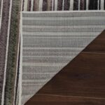 Striped rug corner folded on wooden floor