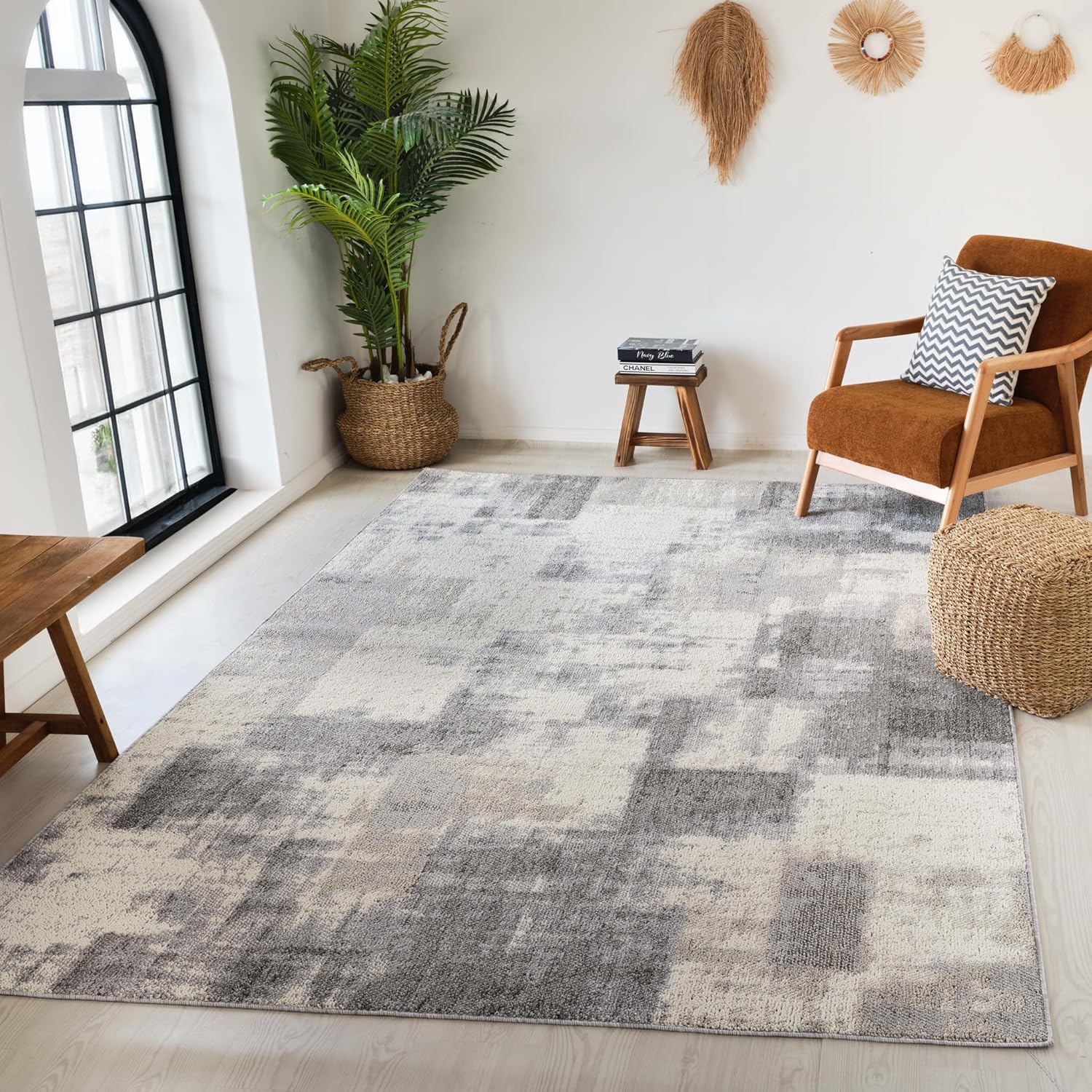 Modern living room with geometric rug and plants.