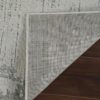 Corner of gray rug on wooden floor