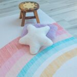 Colorful playroom rug with pillow and stool