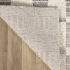 Beige and gray rug on wooden floor.