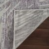Textured rug corner flipped on wooden floor.