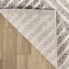 Beige textured rug corner on brown floor