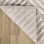 Beige textured rug corner on brown floor