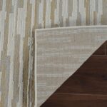 Patterned rug corner folded on wooden floor