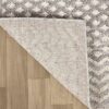 Gray and beige textured rug on wood floor.
