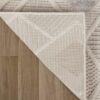 Patterned rug on wooden floor corner view.