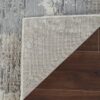Cornered rug on wood floor, underside visible.